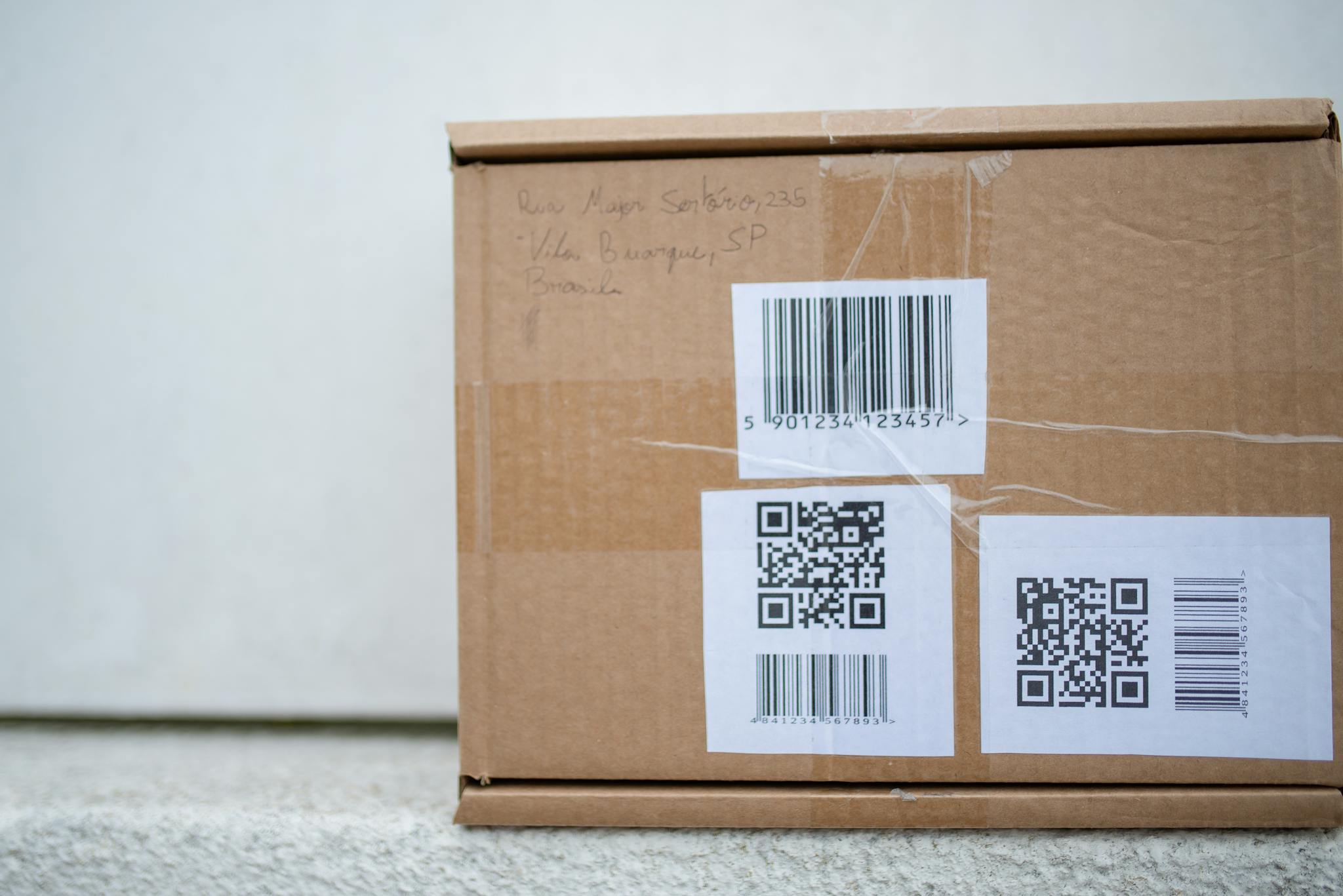 Close-up of a cardboard package with QR codes and a barcode, ideal for delivery and shipping concepts.